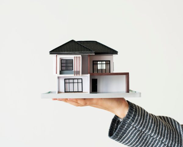 Hand presenting model house for home loan campaign